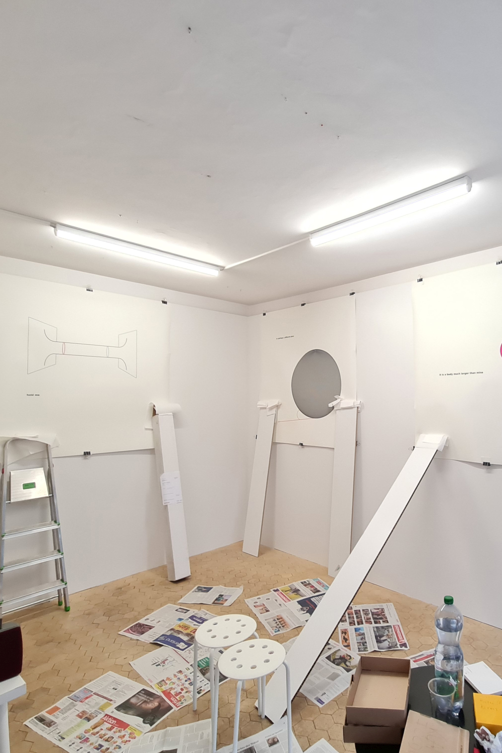 exhibition installation of unstable orbits by alessandro de francesco. the large-format graphics have to be fixed to the wall to smooth them out.